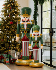 Decorative nutcrackers in front of a Christmas tree with presents.